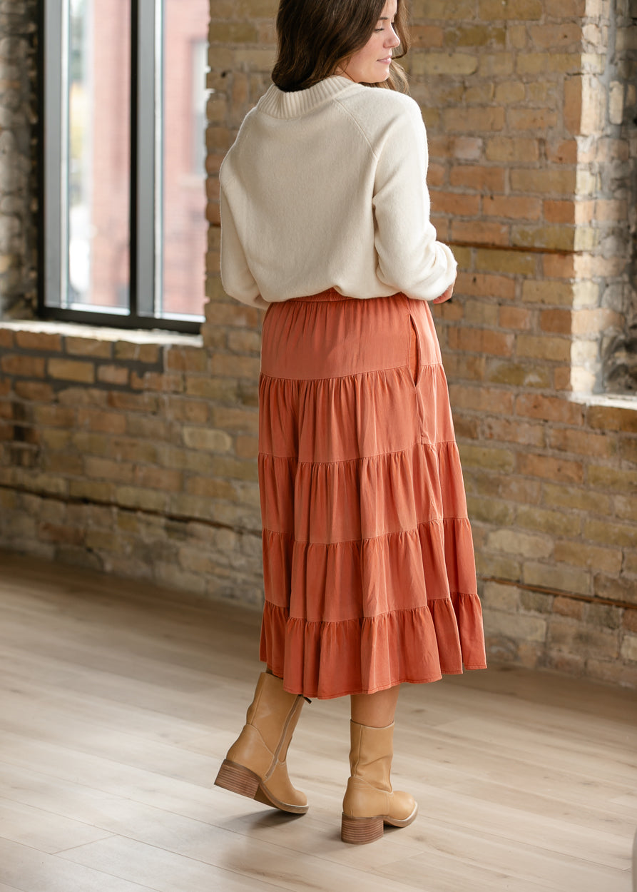 Back of rust washed tiered midi skirt showing the elastic waistband and softly gathered tiers.