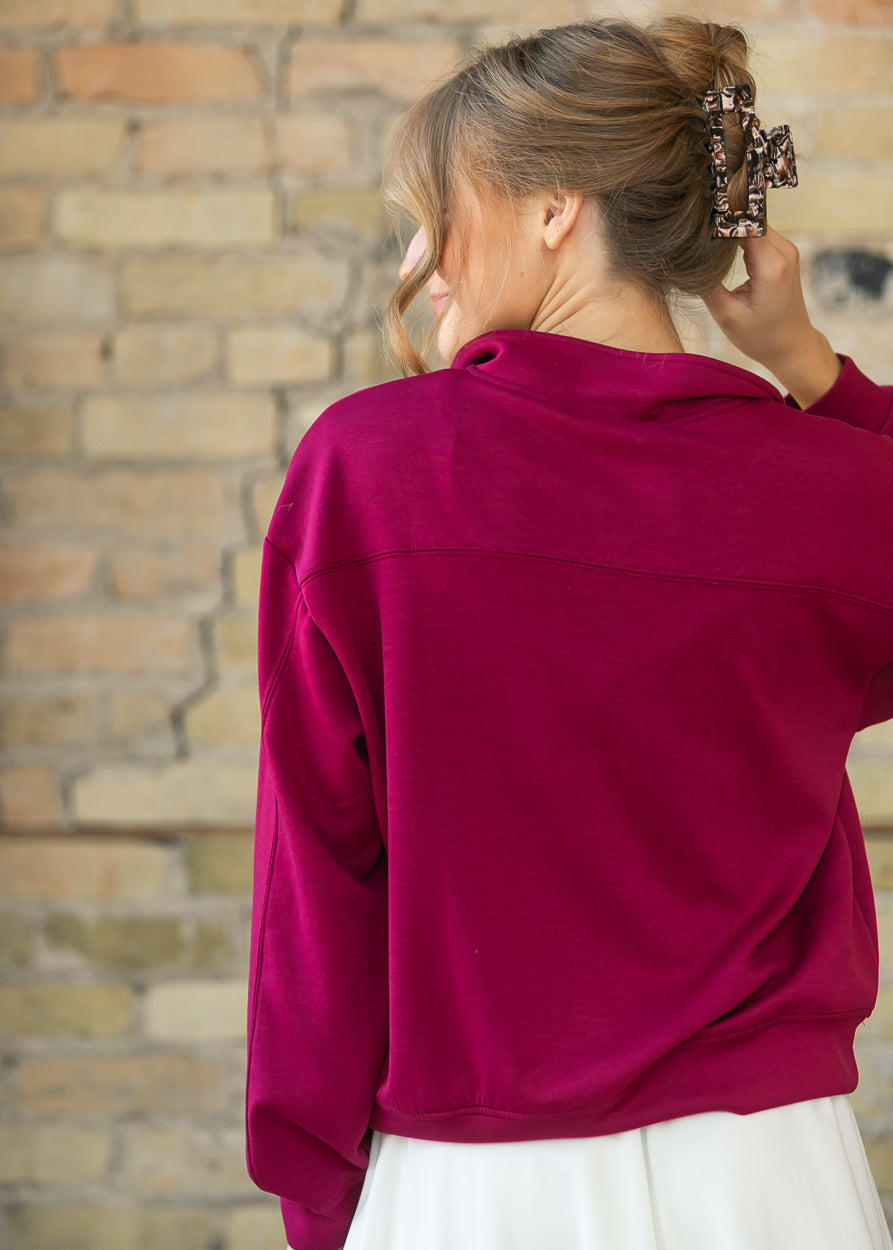 Back of maroon quarter-zip sweatshirt showing the yoke seam and funnel mock neck.