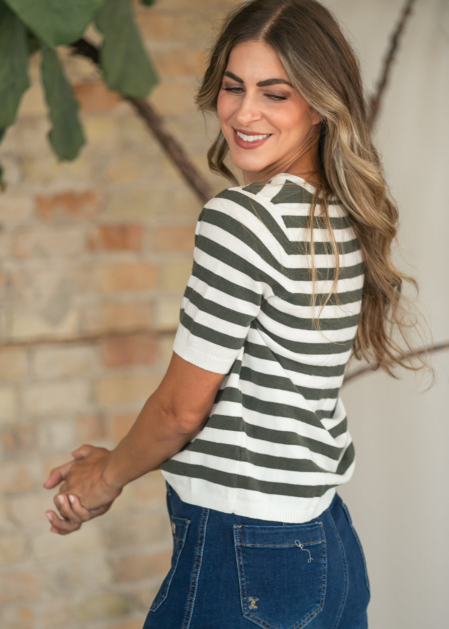 Back of the olive and ivory striped knit top showing ribbed cuffs and hem.