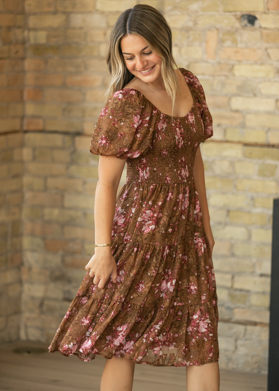 Brown and pink floral midi dress with square neckline, short puff sleeves, and flowing tiered skirt.