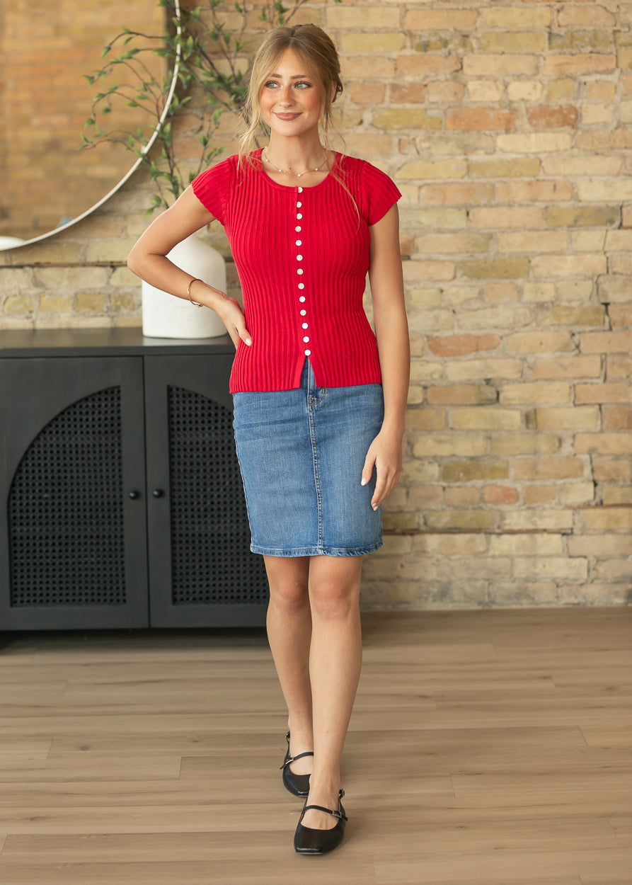 Front view of red ribbed cap sleeve top showing the fitted hip-length cut and contrast buttons.