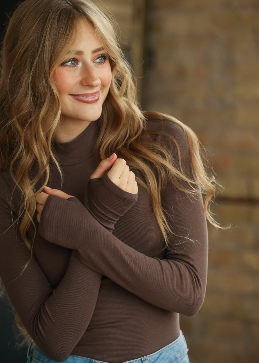 Sadie & Sage brown knit top with mock neckline and fitted silhouette styled with wide leg jeans.