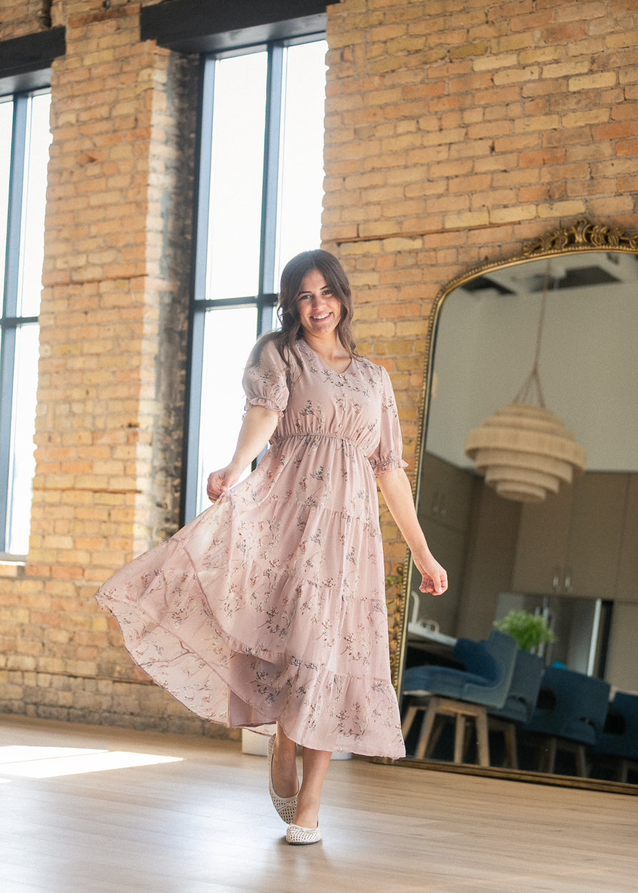 Blush pink floral tiered maxi dress in motion, showing the lightweight skirt and short puff sleeves.