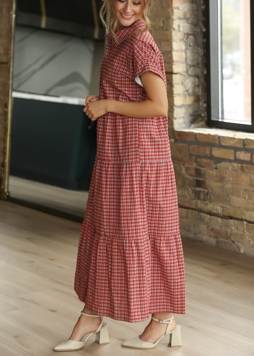 Red gingham tiered dress with functional buttons and side pockets, shown from the front.