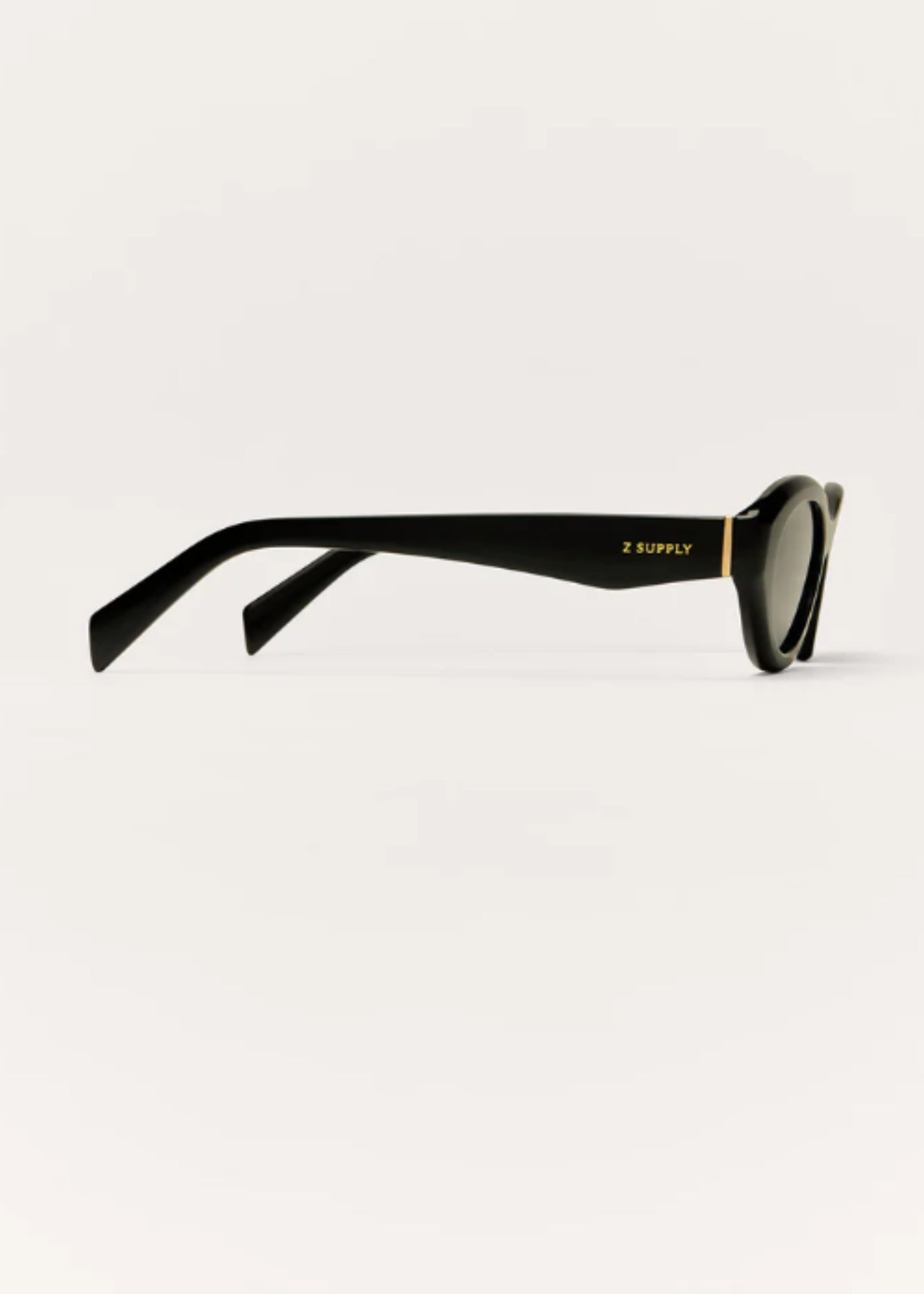 Side profile of black Backstage sunglasses showing slim arm detail and gold logo accent.
