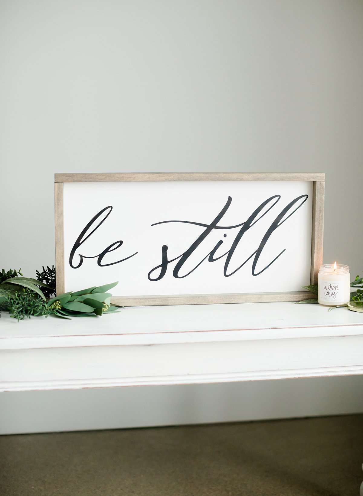 Wood Frame Signboard with the words, "Be Still" written on it in script font.