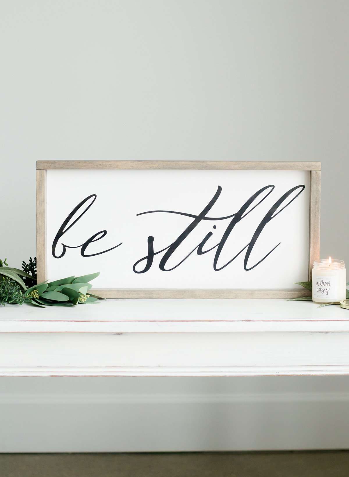 Wood Frame Signboard with the words, "Be Still" written on it in script font.