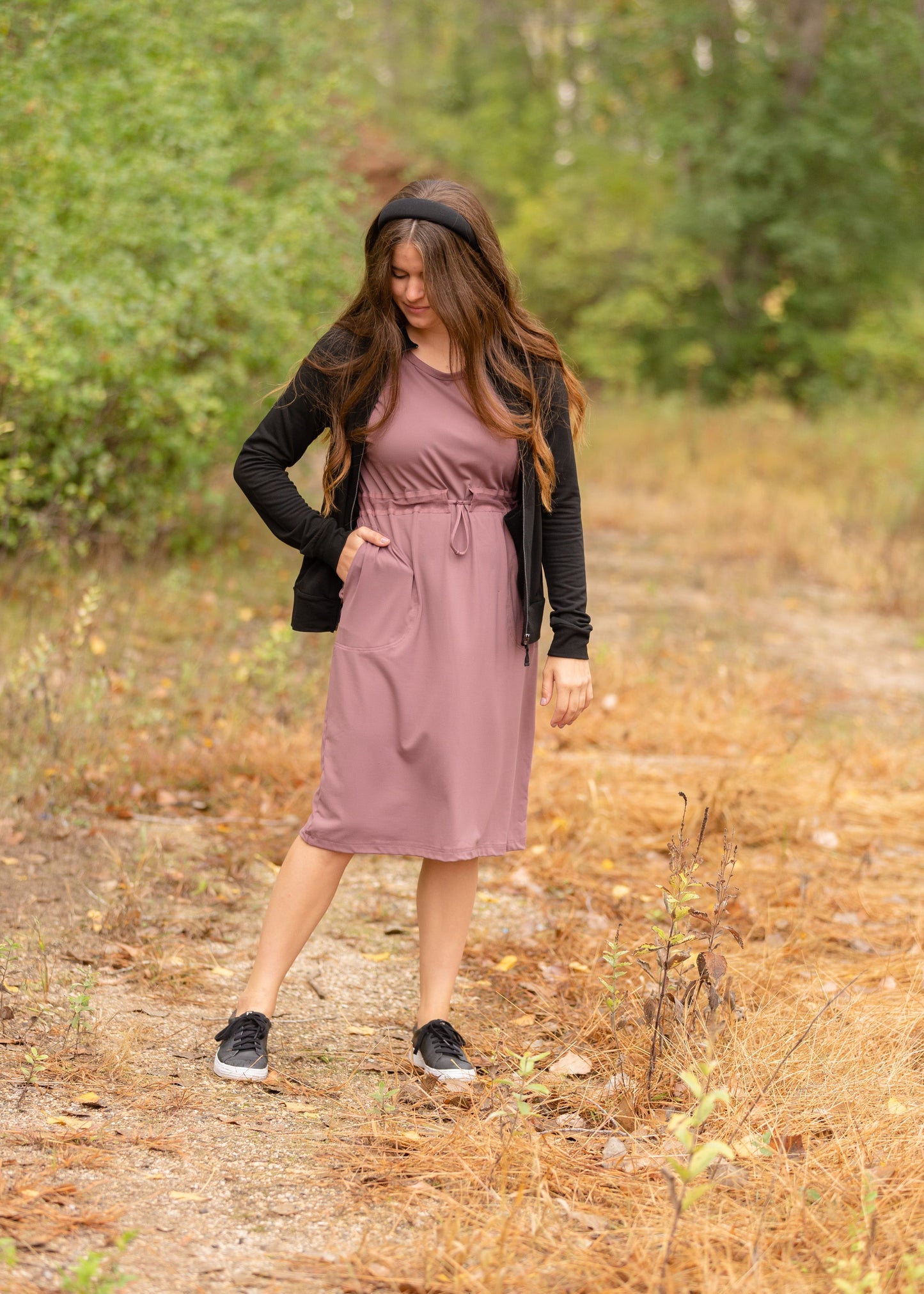This is a Cinch Waist Athletic midi dress in a purpley taupe color that has a mesh detail and large side pockets.