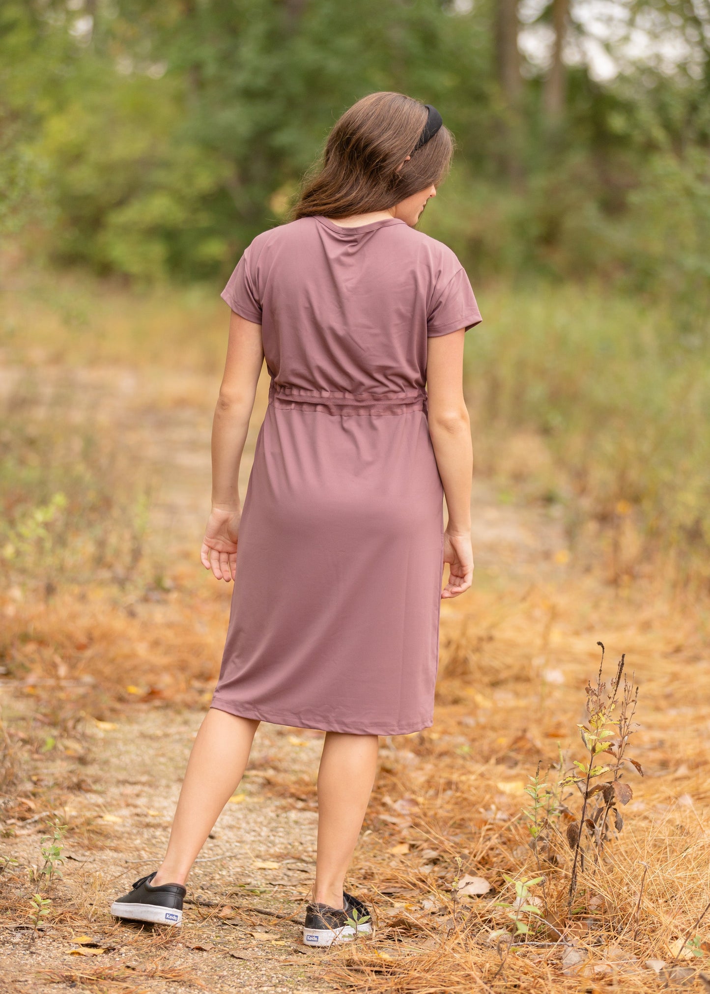 This is a Cinch Waist Athletic midi dress in a purpley taupe color that has a mesh detail and large side pockets.