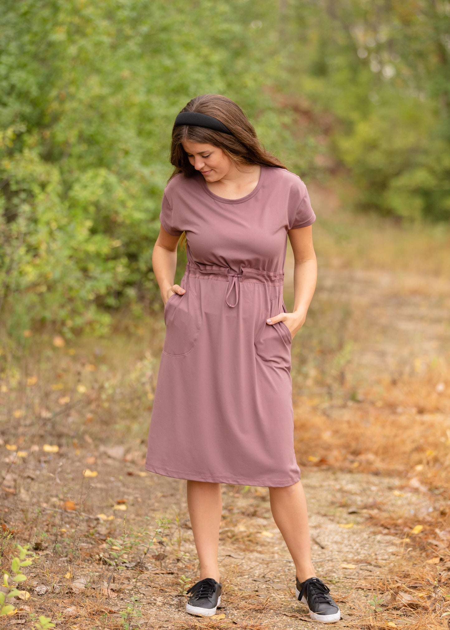 This is a Cinch Waist Athletic midi dress in a purpley taupe color that has a mesh detail and large side pockets.