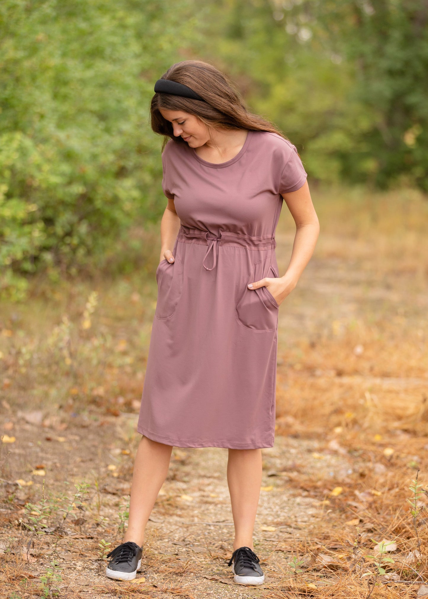 This is a Cinch Waist Athletic midi dress in a purpley taupe color that has a mesh detail and large side pockets.