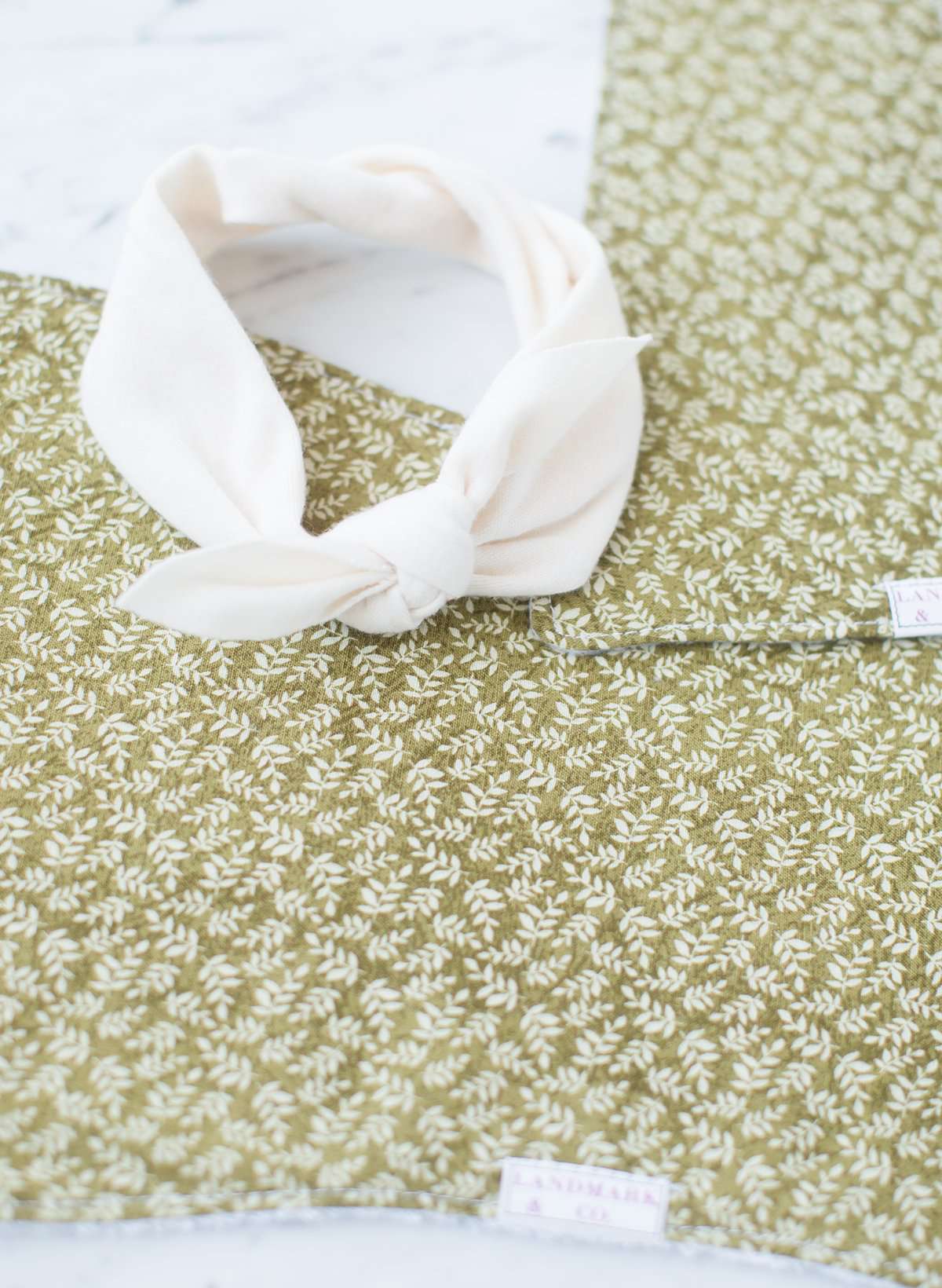 This is a sage colored baby burp cloth, baby bandana and headband gift set.