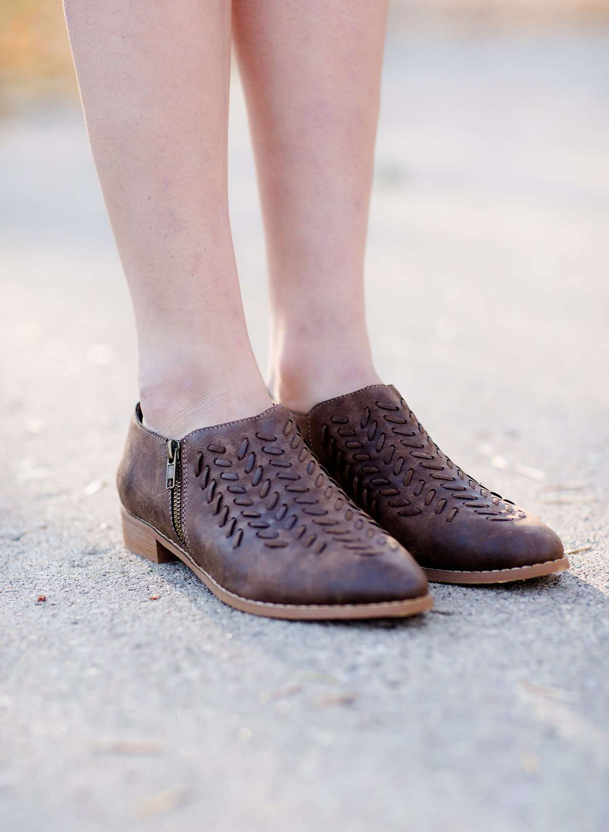 Women's braided ankle bootie in black or brown. These have a stacked heel and feature a size zipper closure.