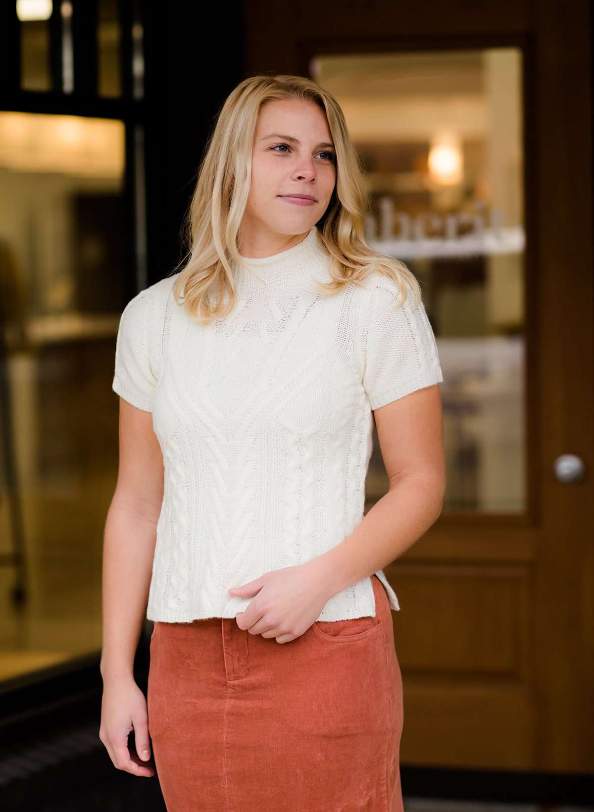 This is a mock neck cable knit short sleeve sweater in ivory.