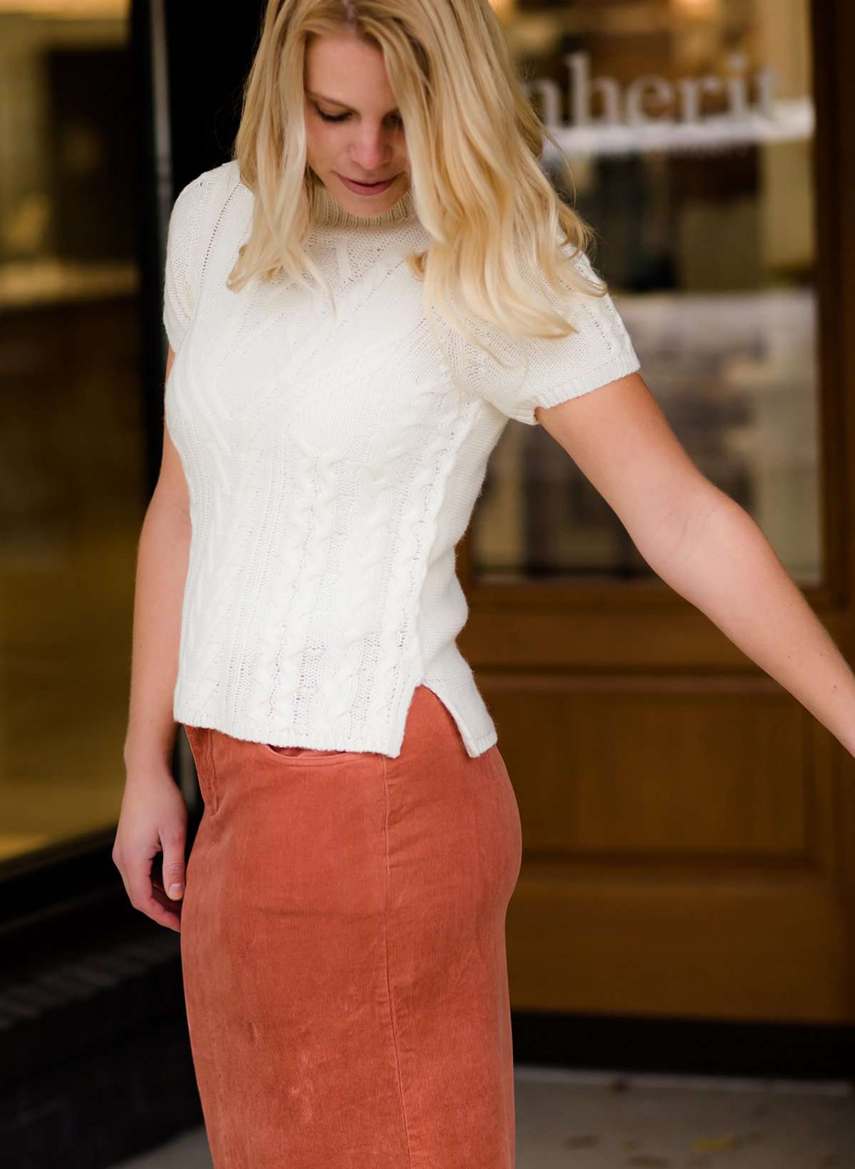 This is a mock neck cable knit short sleeve sweater in ivory.