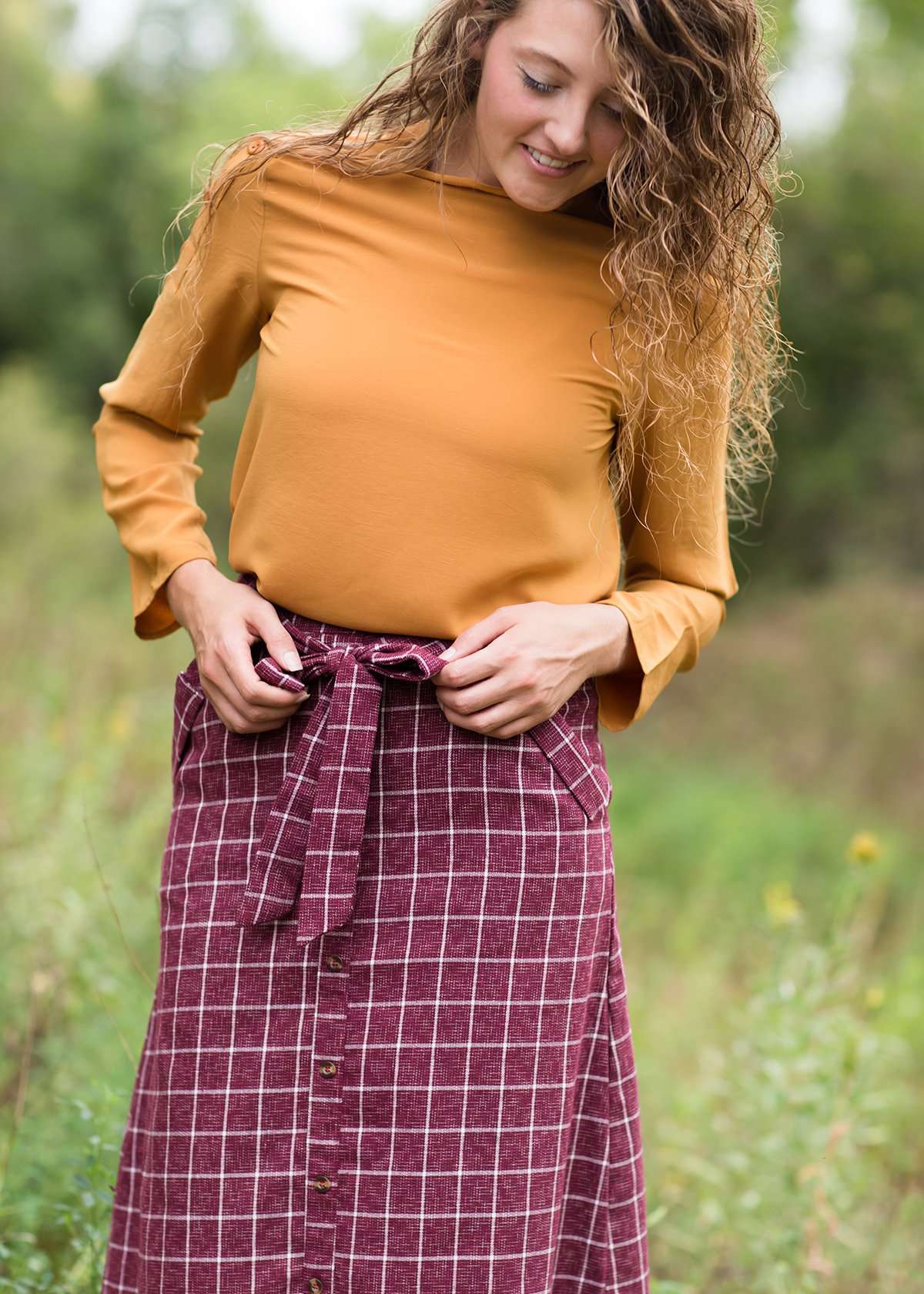 Burgandy with ivory stripe checkers on this below the knee midi skirt and buttons down the front with a back zip, detachable fabric belt and 2 front pockets.