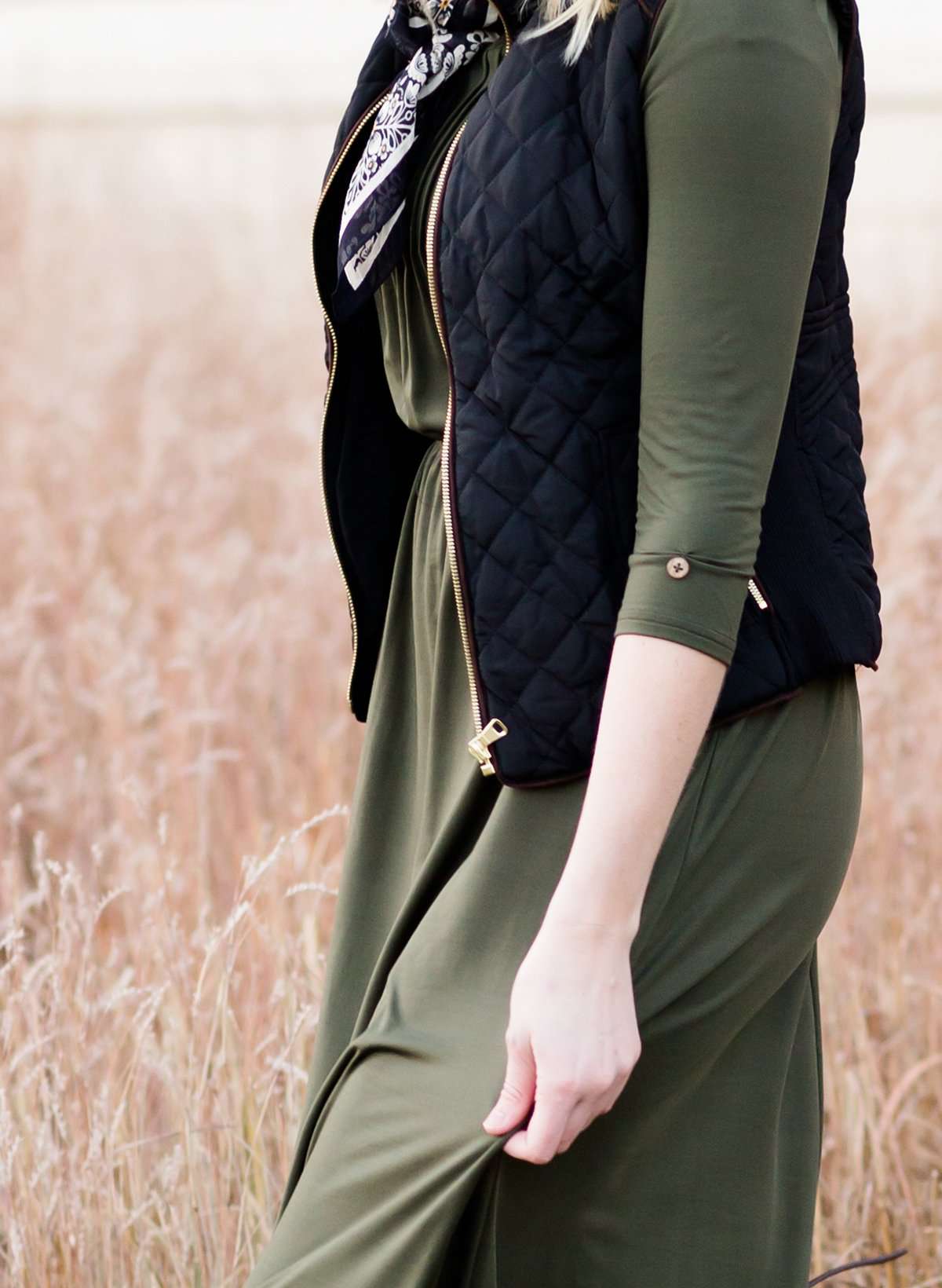 Woman wearing a cold weather, quilted puffer vest. This vest comes in mauve, black, navy and wine. It features pockets and a front zip.