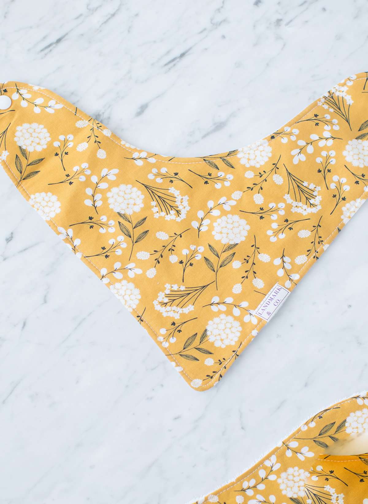 This is a mustard colored baby burp cloth, baby bandana and headband gift set.