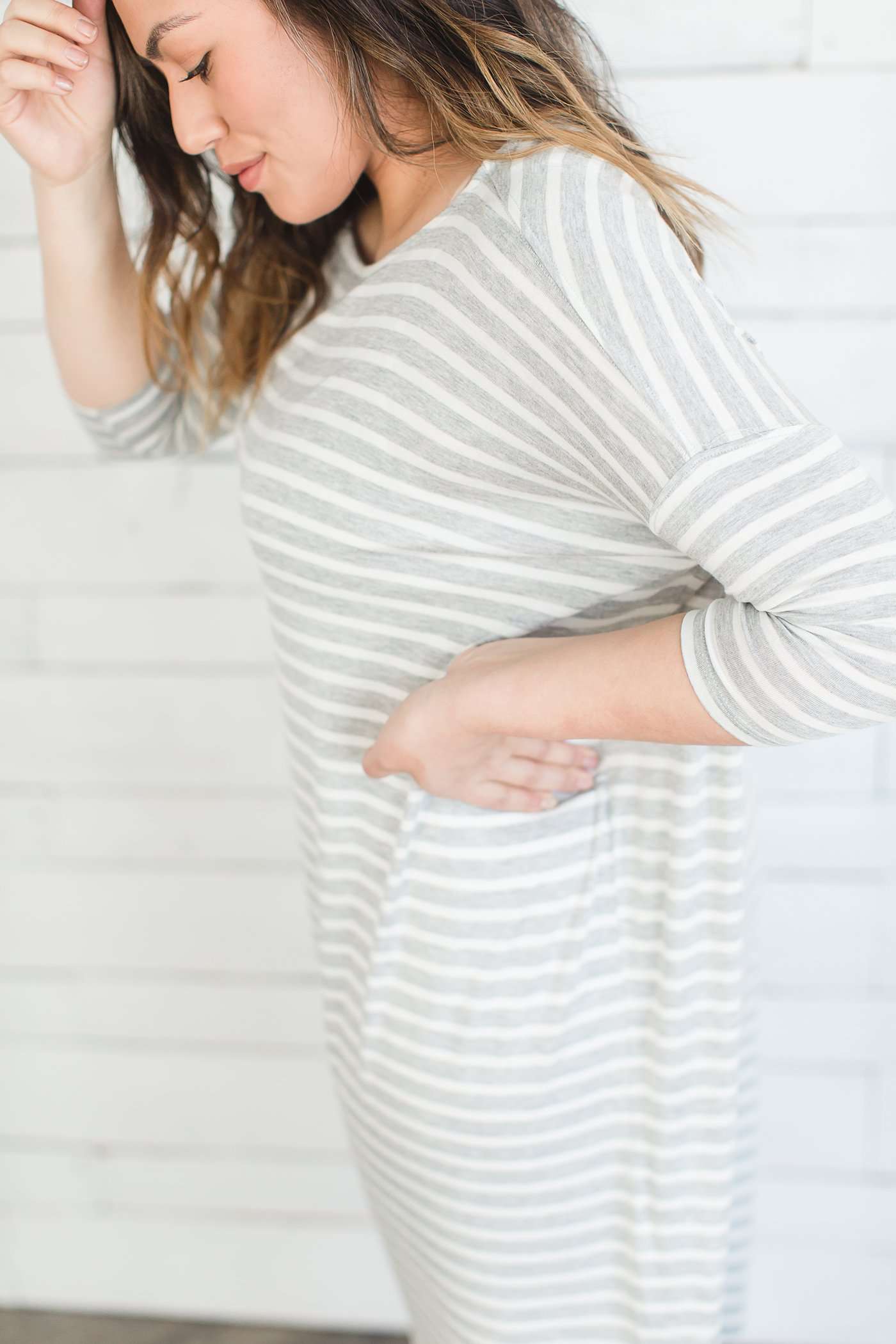 grey and white striped three quarter length sleeve midi dress with a modest crew neck top and side slit.