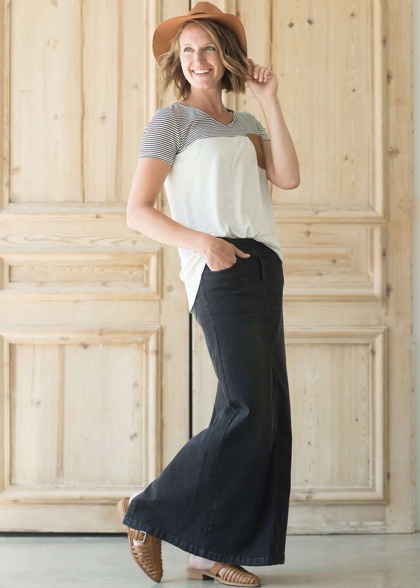 Woman wearing a modest long black denim skirt with pockets