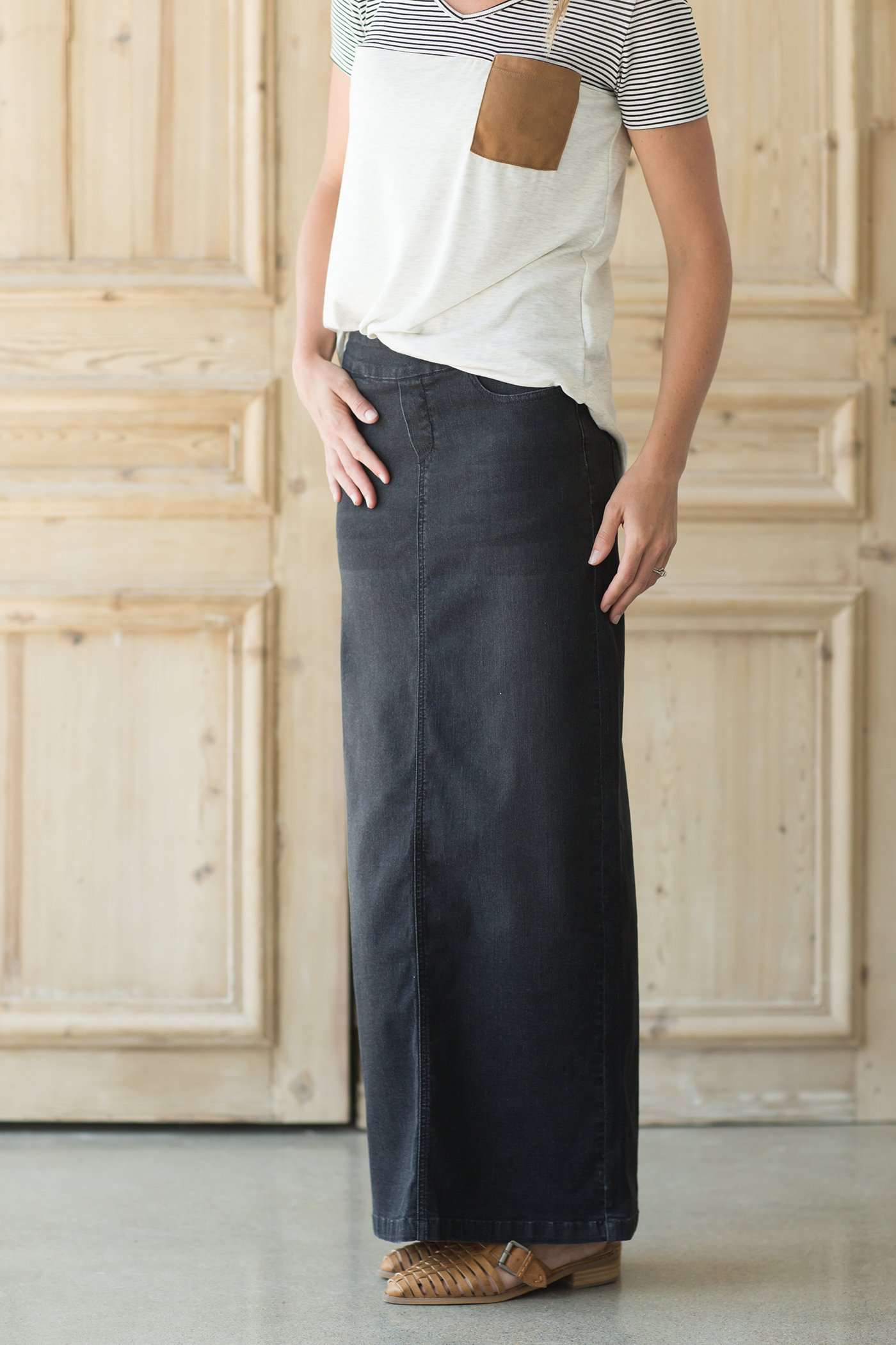 Woman wearing a modest long black denim skirt with pockets