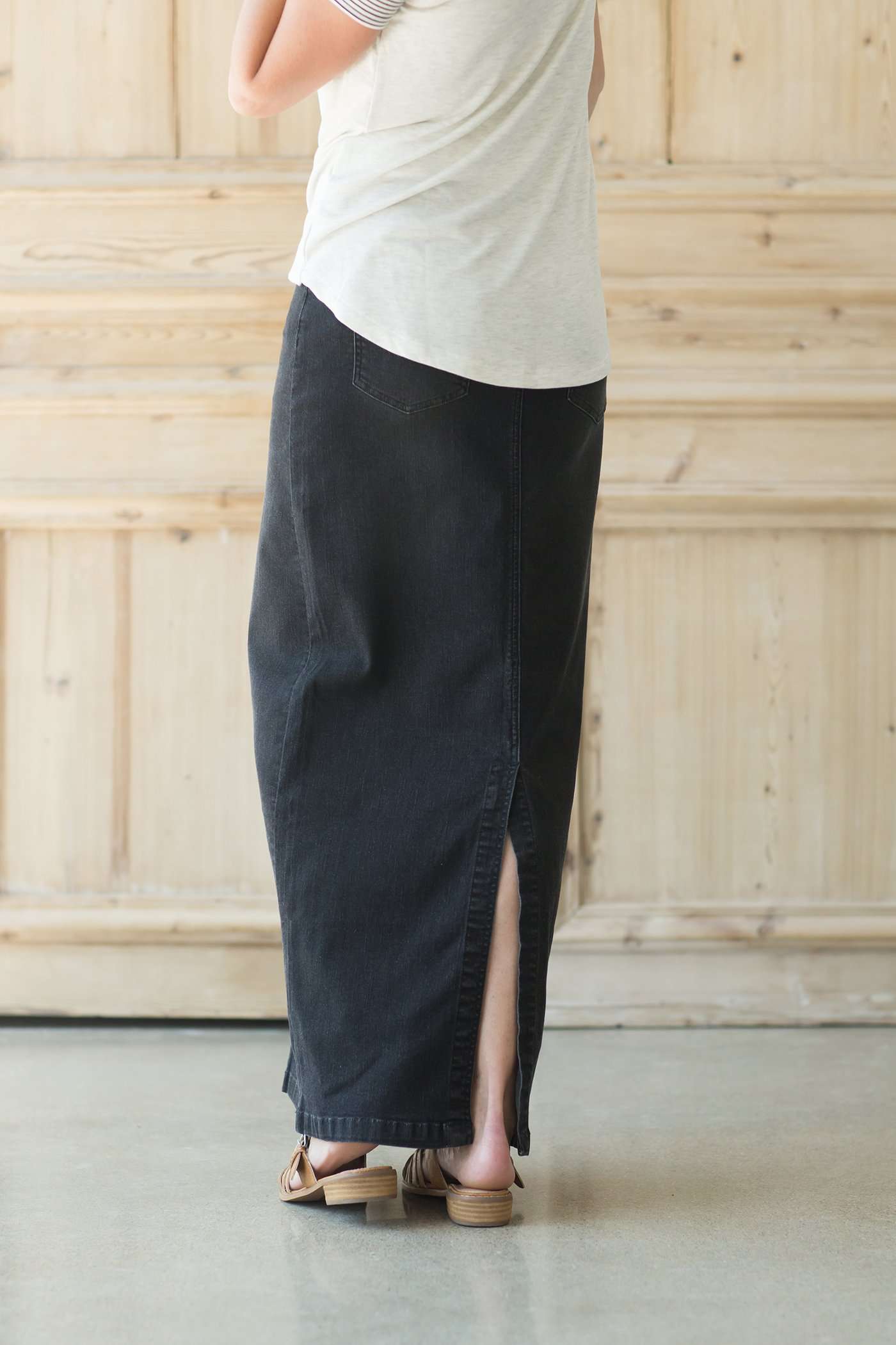 Woman wearing a modest long black denim skirt with pockets