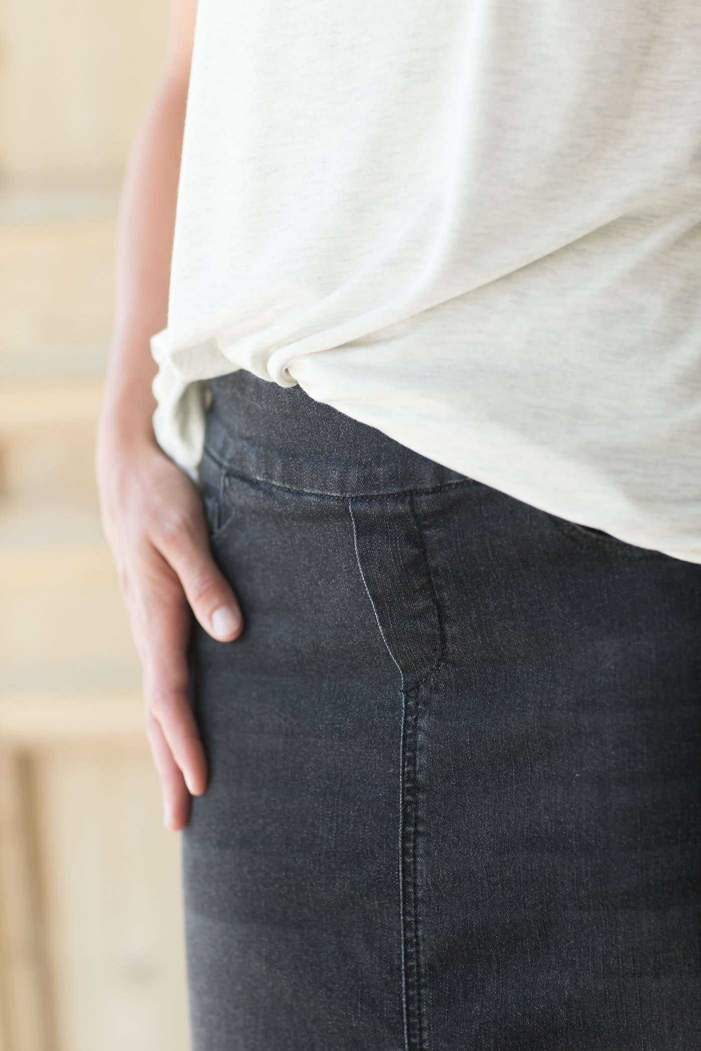 Woman wearing a modest long black denim skirt with pockets