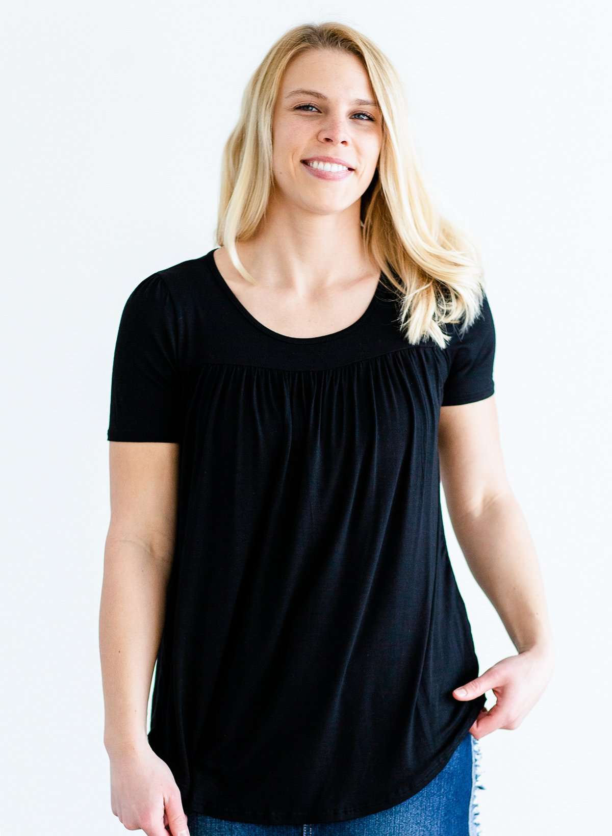 Woman wearing a modest black top with a denim jean skirt