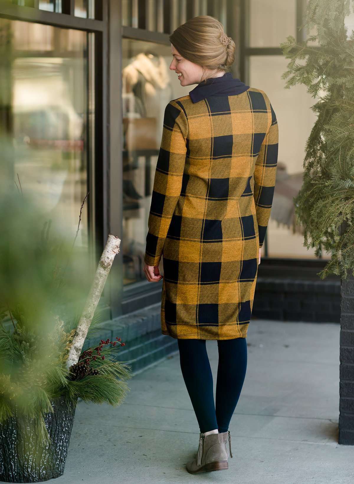 Woman wearing a Mustard and Navy buffalo check, flannel shift dress at Inherit Clothing Company.