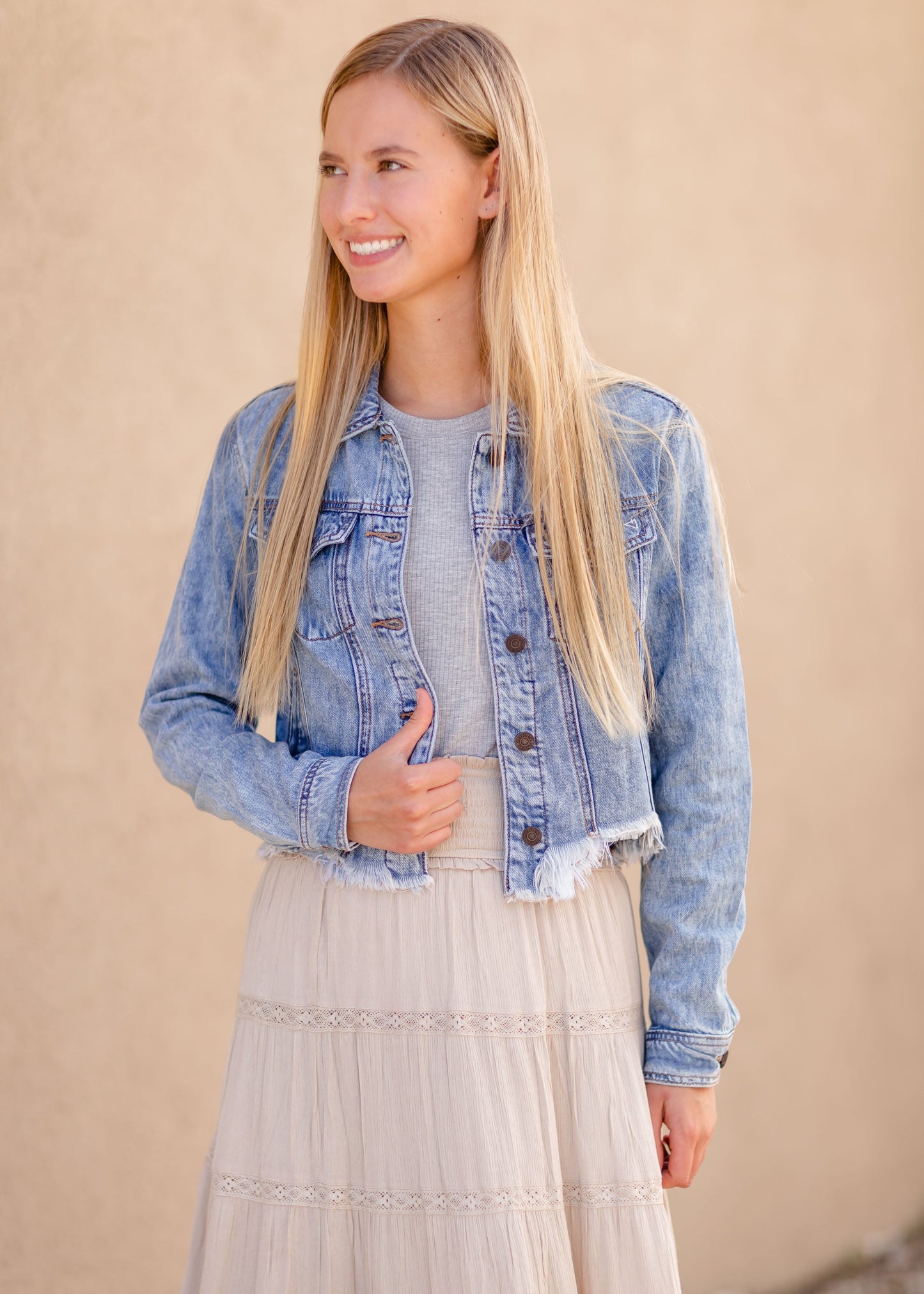 Frayed Light Wash Denim Jean Jacket with brass front buttons, a classic collar and a frayed hem.