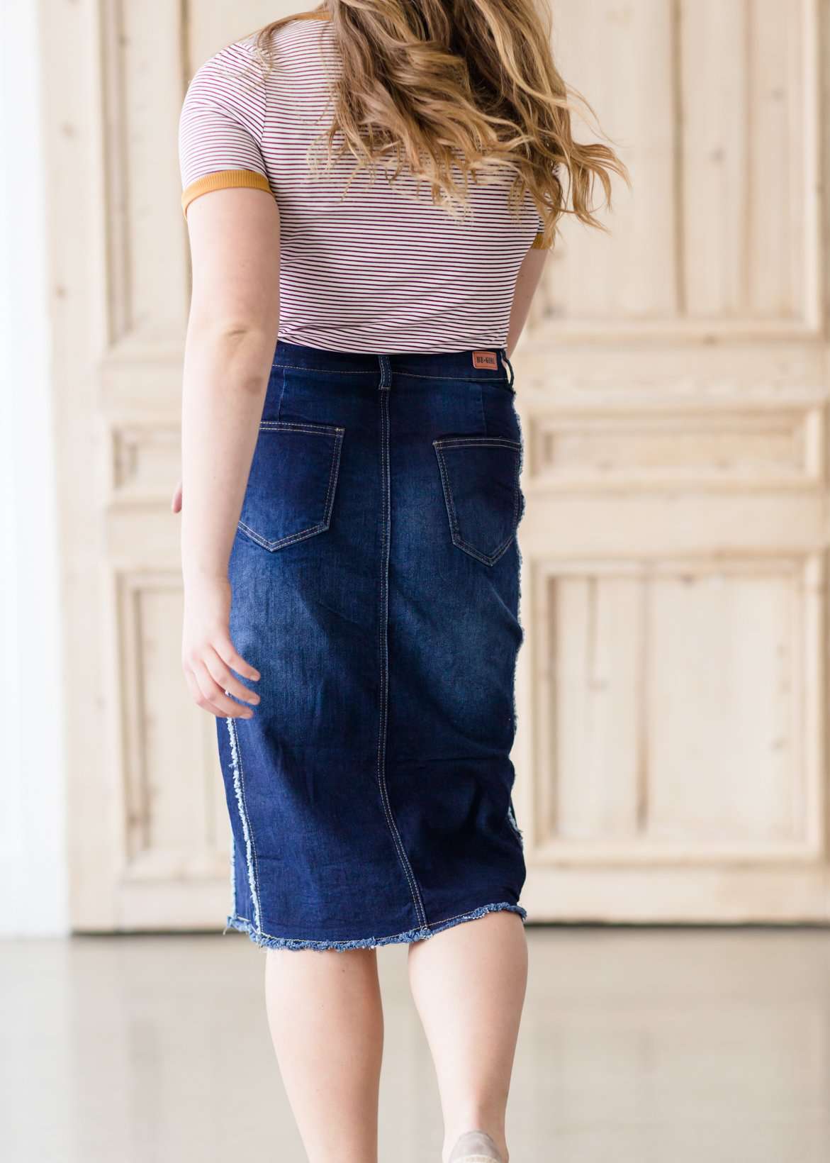 modest woman wearing a fringe dark denim below the knee skirt