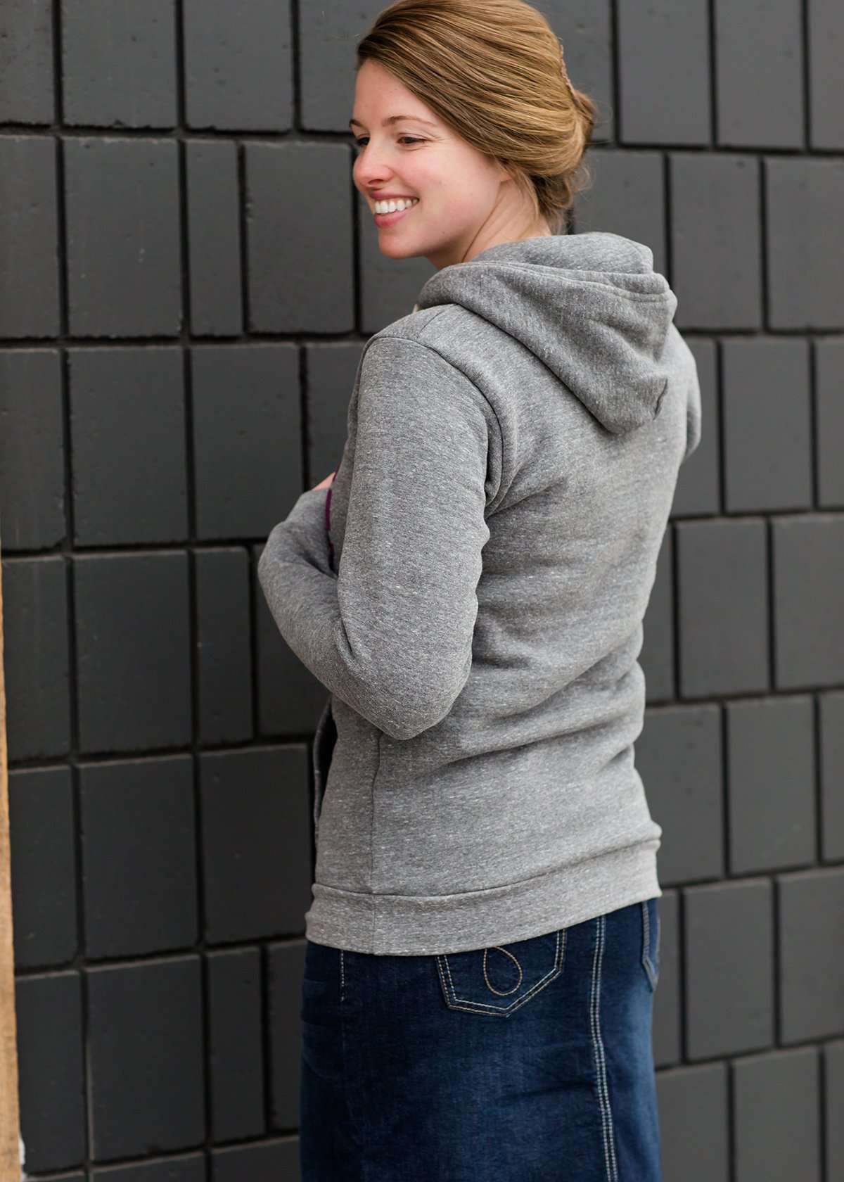 Triblend Minnesota hoodie on a young woman, the hoodie is navy with a gold MN emblem on front and gray with a purple MN emblem on front.