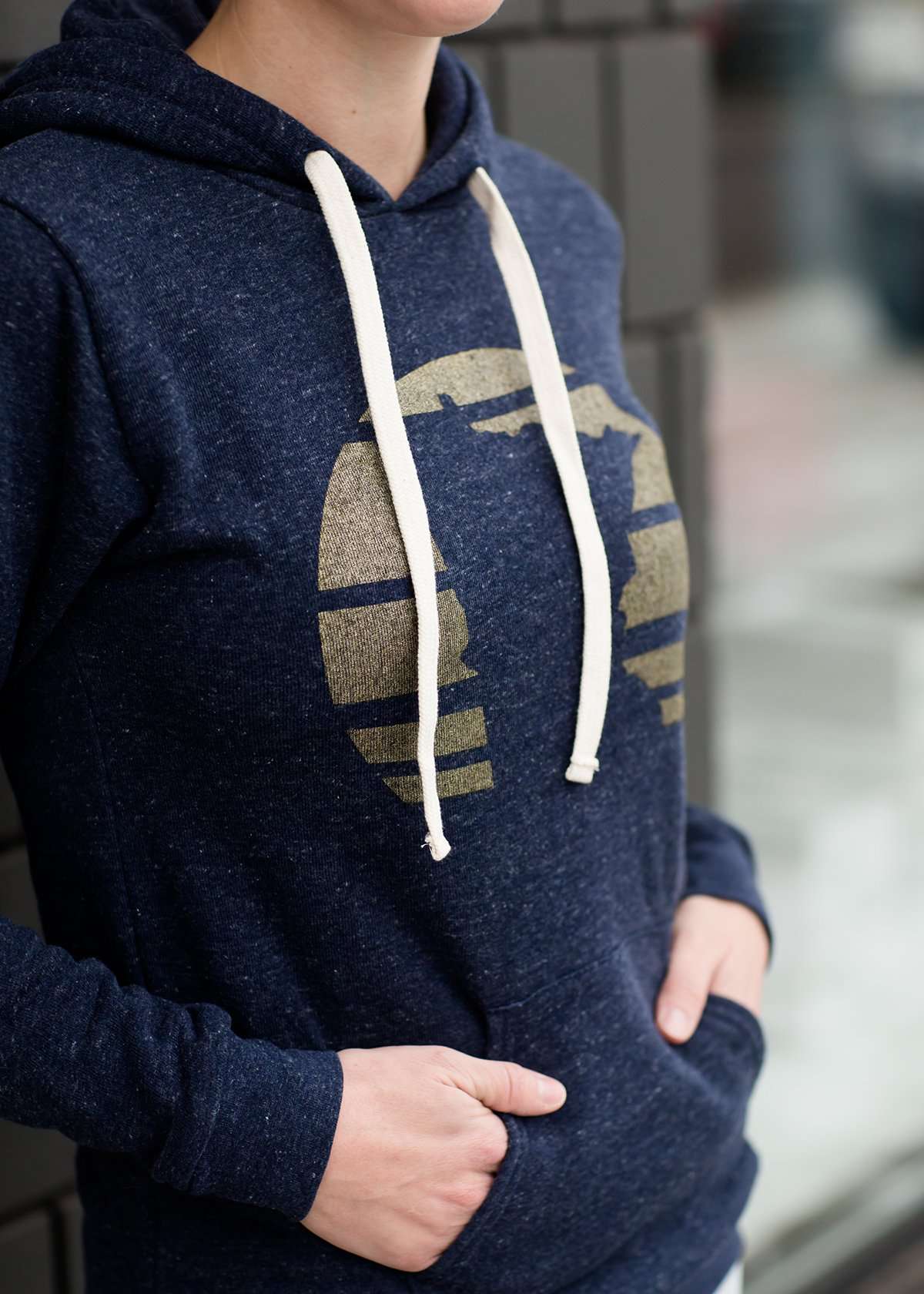 Triblend Minnesota hoodie on a young woman, the hoodie is navy with a gold MN emblem on front and gray with a purple MN emblem on front.