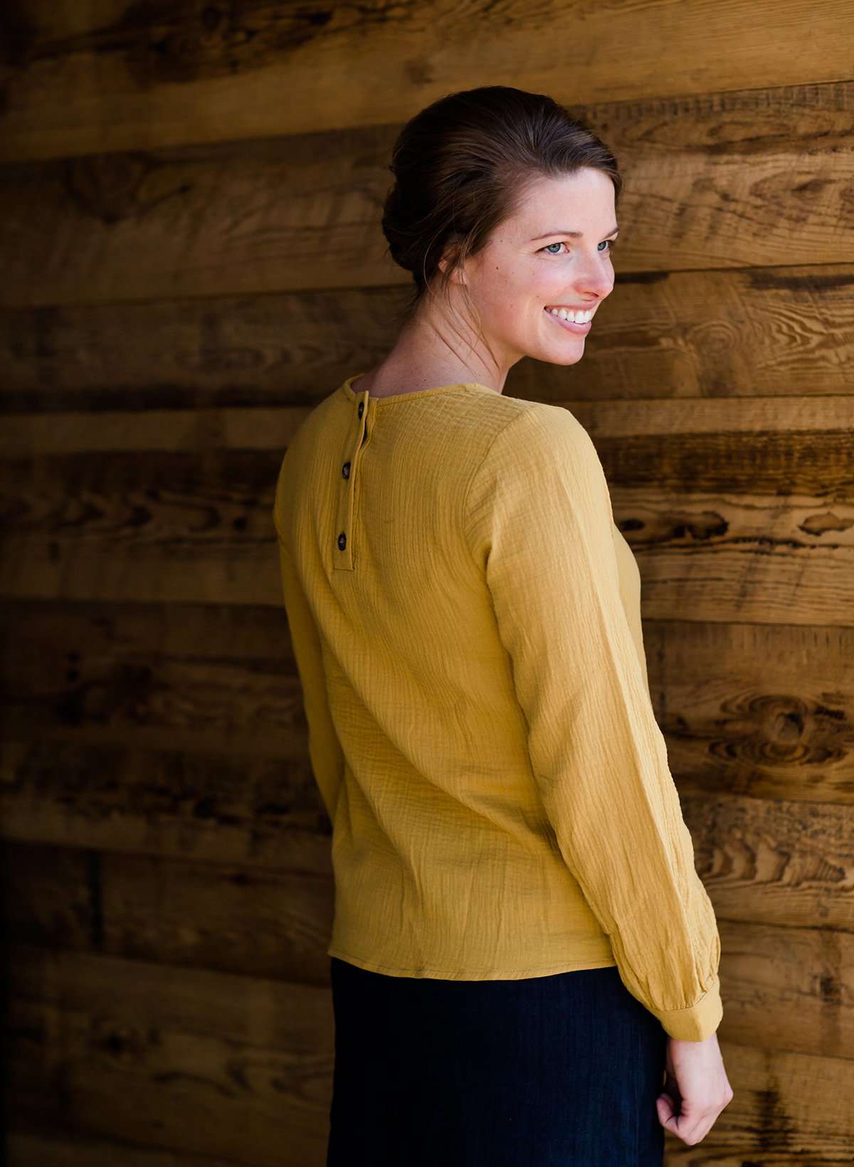 Woman wearing a mustard tie front top with back buttons
