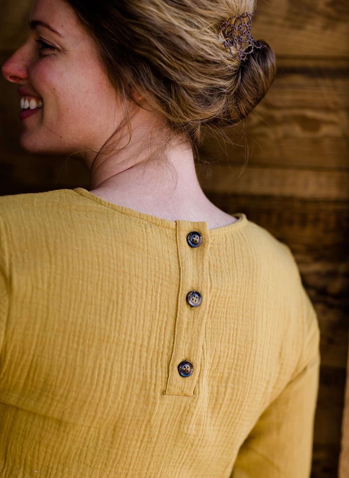 Woman wearing a mustard tie front top with back buttons