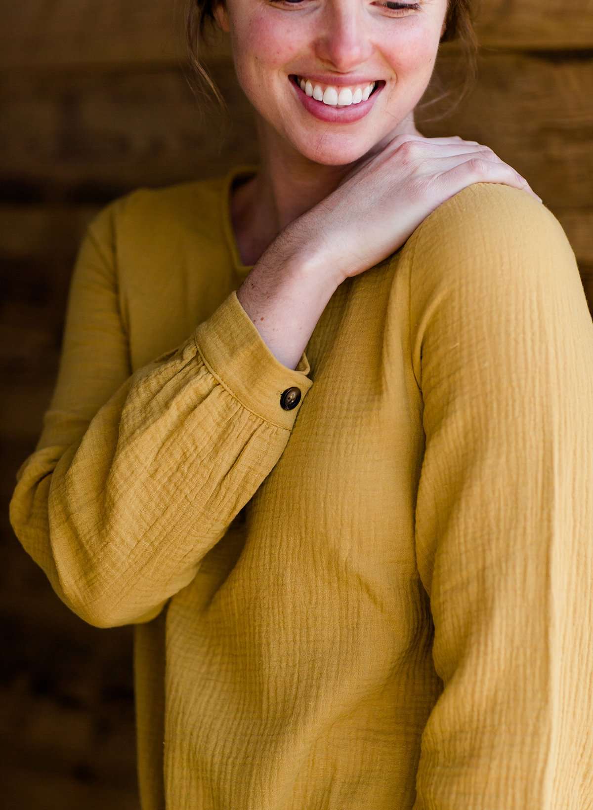 Woman wearing a mustard tie front top with back buttons