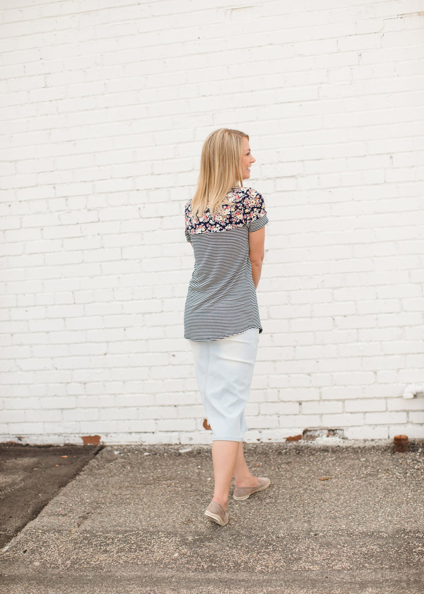 Young lady wearing a light denim below the knee jean skirt.