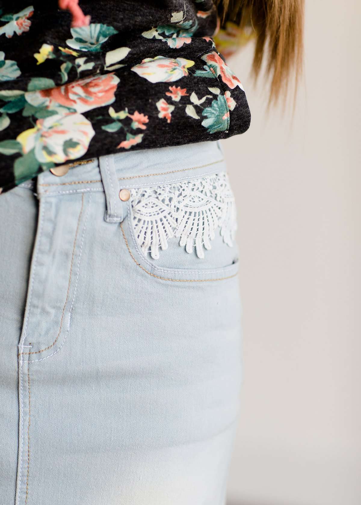 Young lady wearing a light denim below the knee jean skirt.