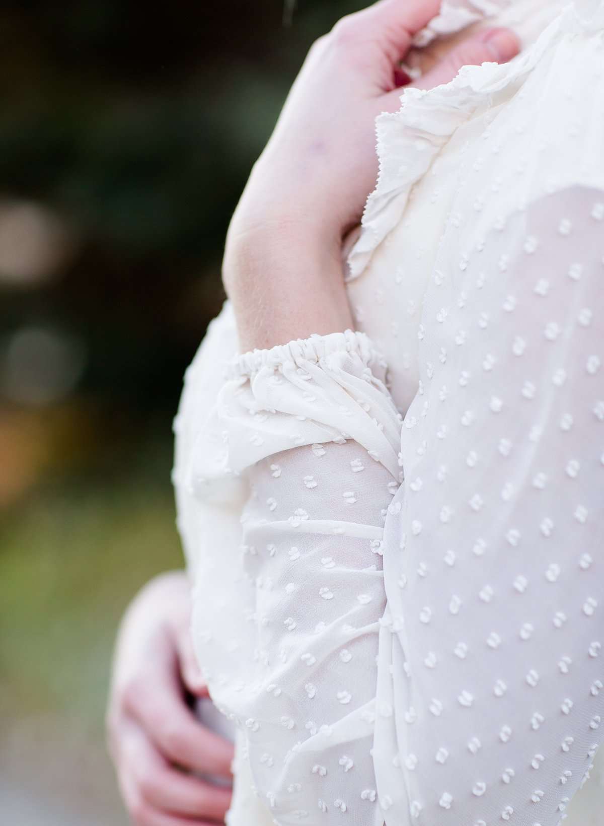 Young woman wearing a vintage inspired ruffle and layered cream colored blouse. This blouse features ruffles and ribbon details.