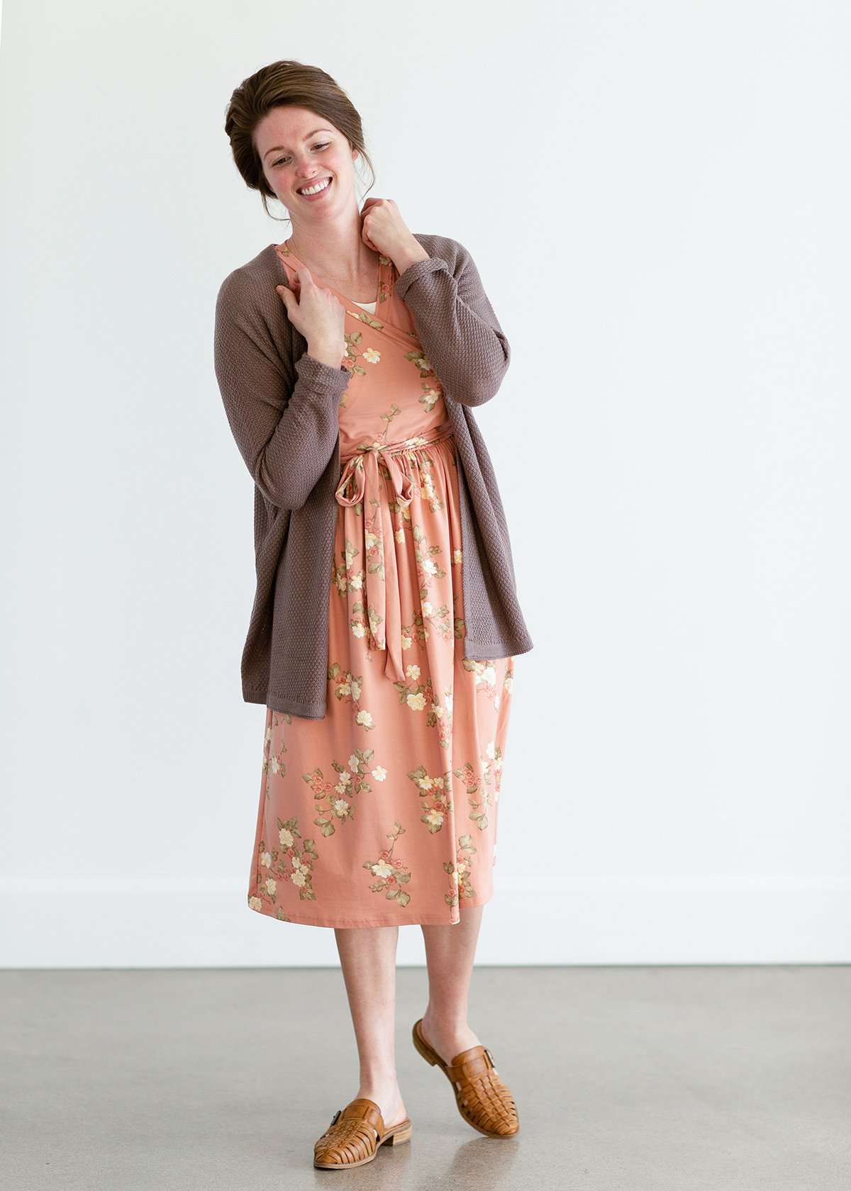Woman wearing a lightweight knit cardigan in navy, taupe or cream.