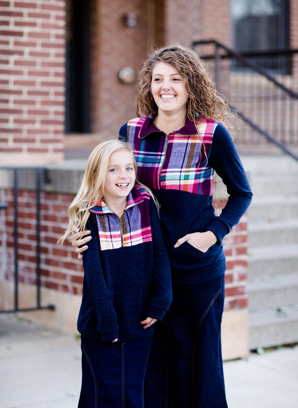 This half zip pullover features a front pouch pocket and a beautiful color block print of fuchsia, teal and mustard! It also is a mommy and me style.