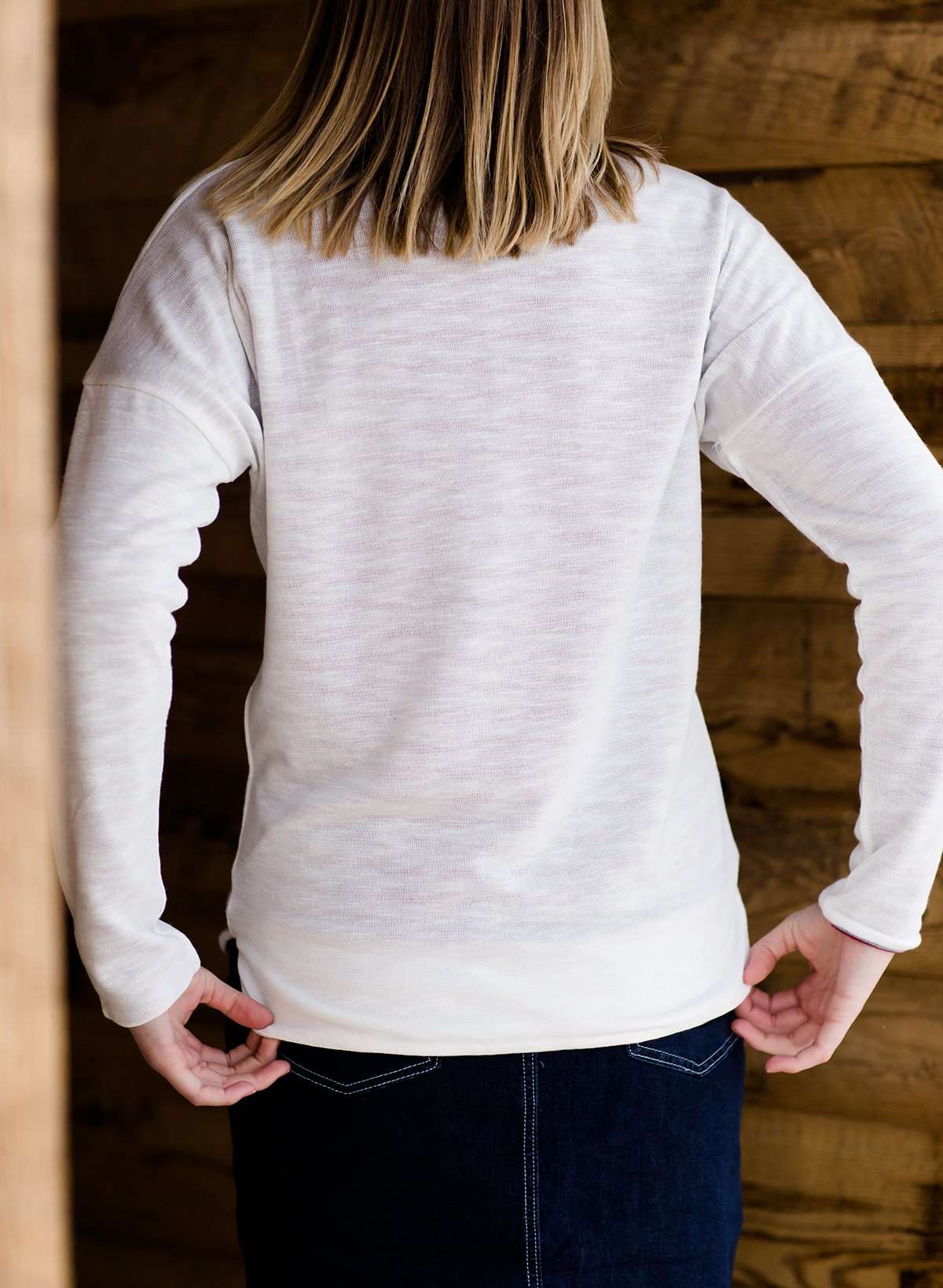 woman wearing a reversible knit top in purple and white