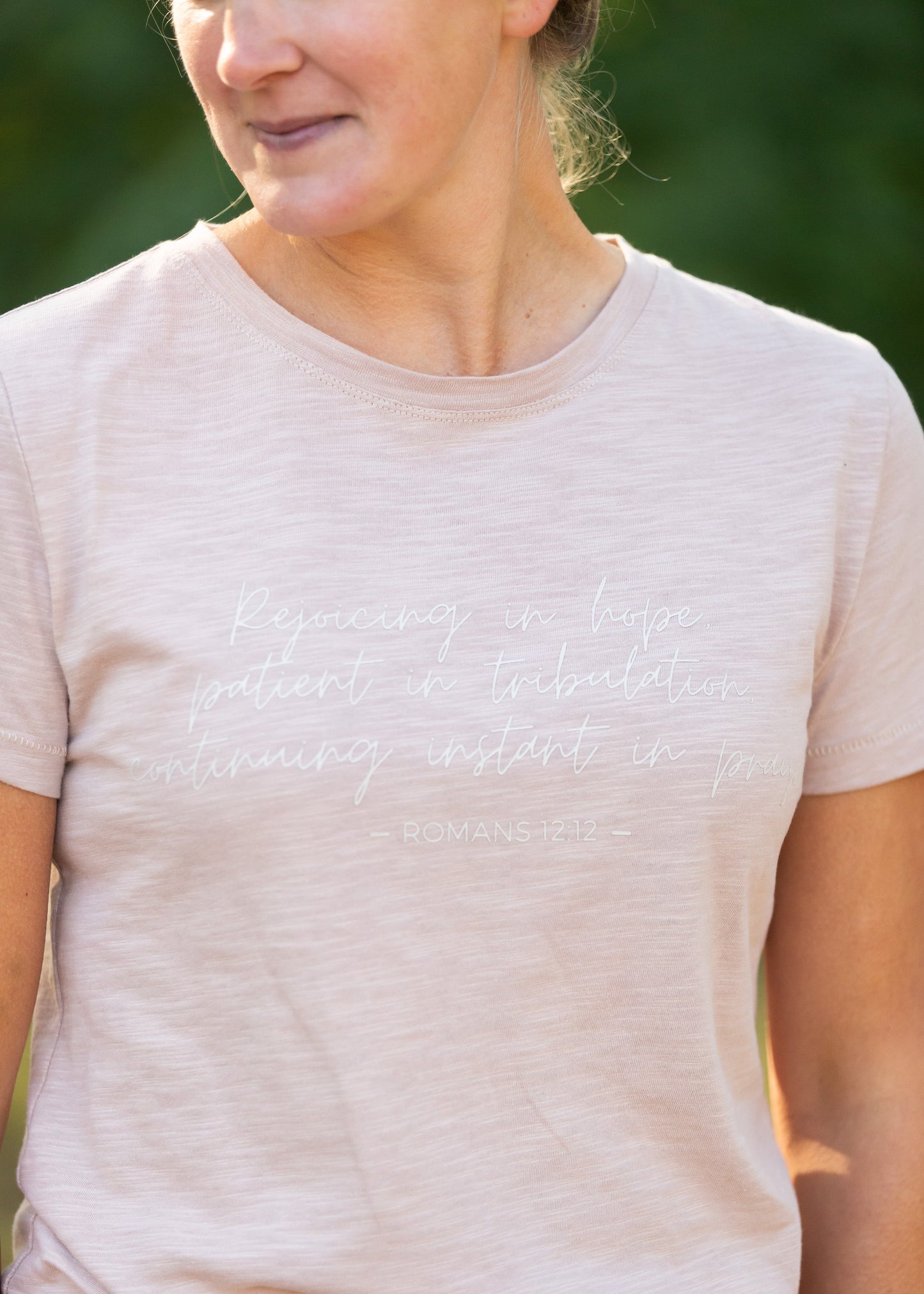 This custom Romans Graphic Tee is an Inherit Design tailored in a feminine fit. The sleeve length is a true short sleeve that will go with anything. It is a pink with a slight heathered look that isn't see-through! The white writing on the front says "Rejoicing in hope, patient in tribulation; continuing instant in prayer." - Romans 12:12 for a daily reminder in your walk with the Lord!