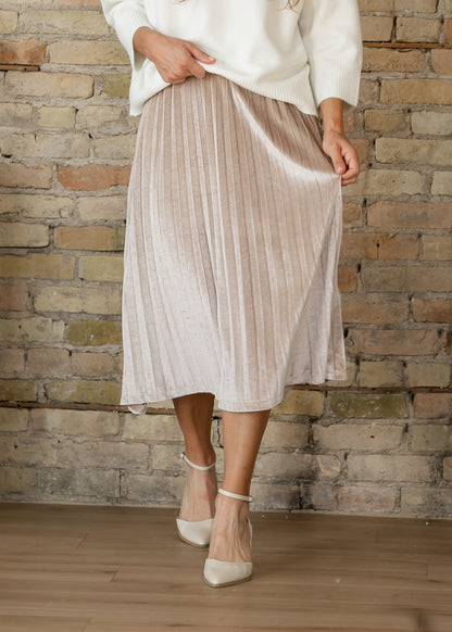 Front of tan pink velvet midi skirt showing its soft sheen, narrow pleats, and gently flared silhouette.