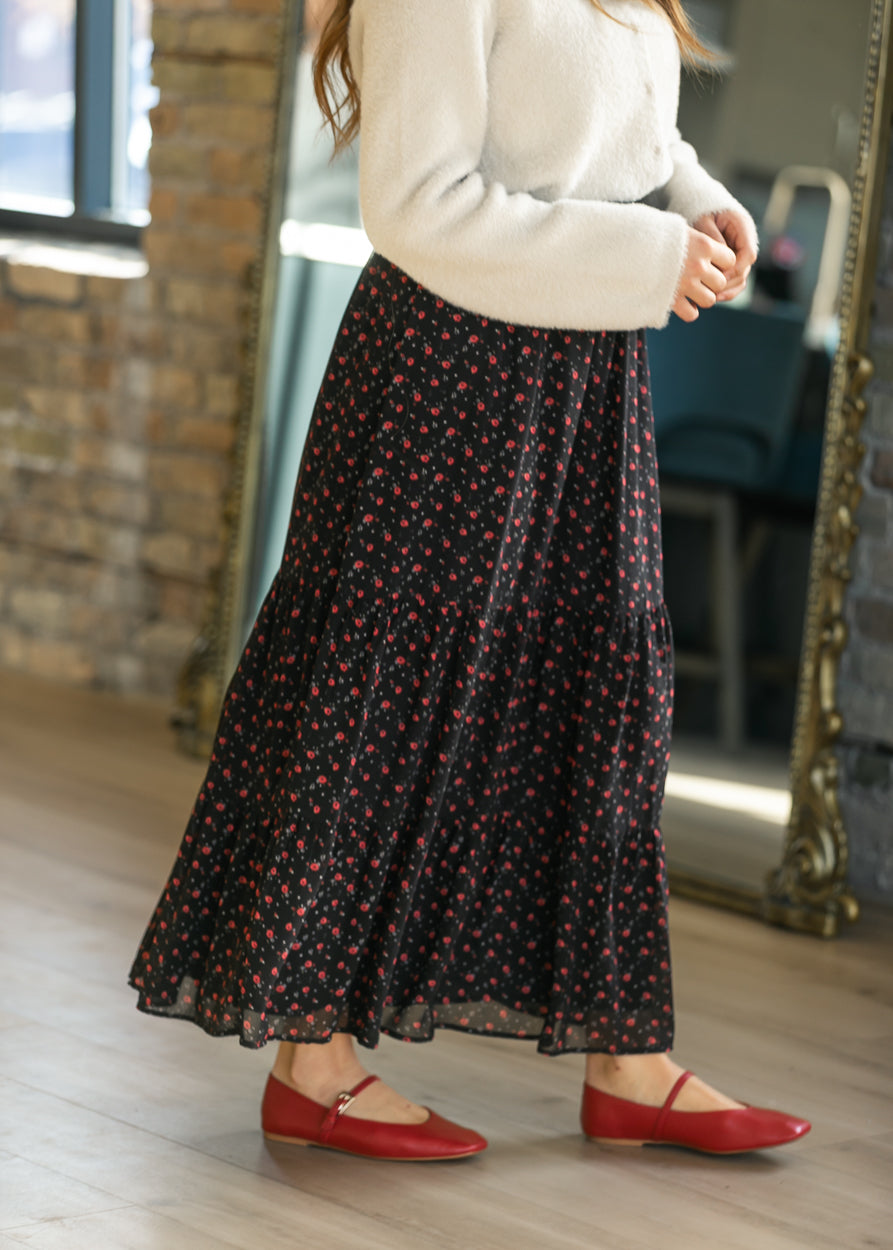 Close-up of Lynn maxi skirt showing small red flowers, gathered tier seams, and a sheer outer hem.