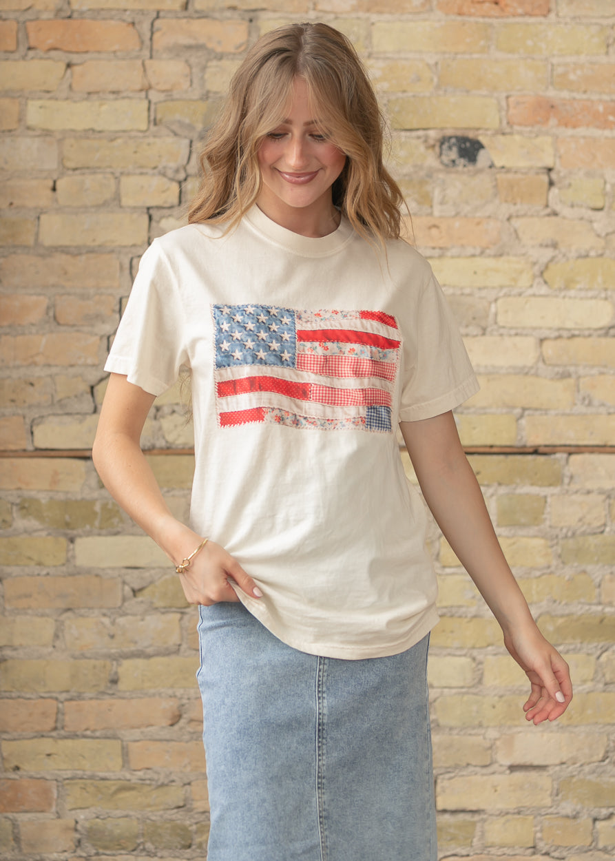 Women's cream American flag graphic t-shirt styled with denim skirt