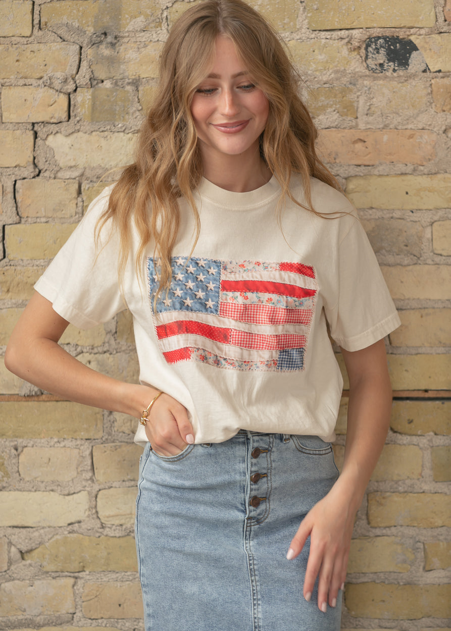 Cream graphic tee featuring a patchwork American flag design