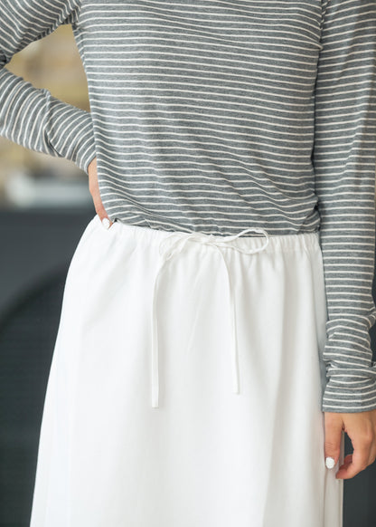 Close-up of the adjustable drawstring waist on the ivory midi skirt.