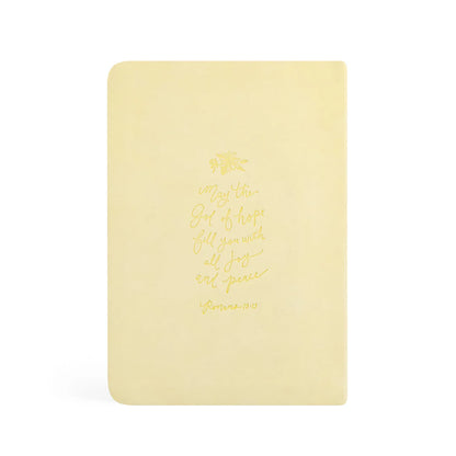 Back cover of the butter-yellow Belfast notebook with a gold-foil Romans 15:13 verse and a small daffodil sprig.