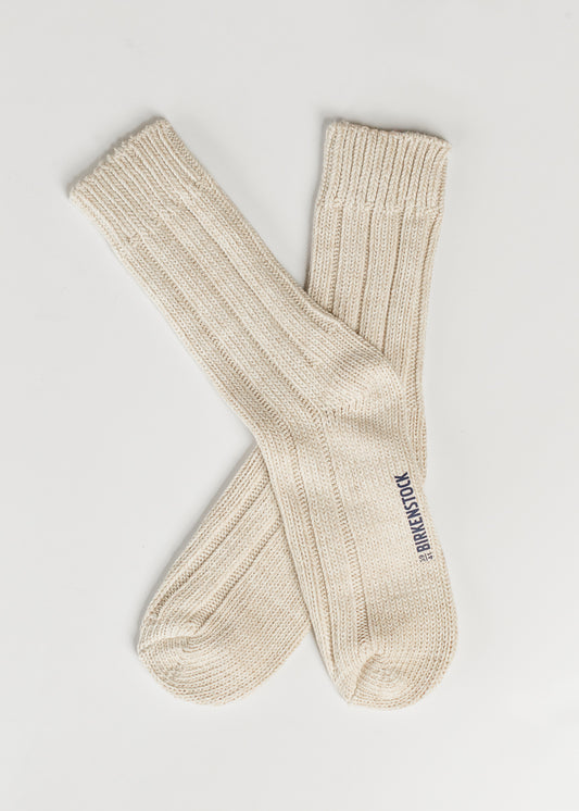 Pair of off white cotton crew socks featuring cozy ribbed detailing and classic knit texture